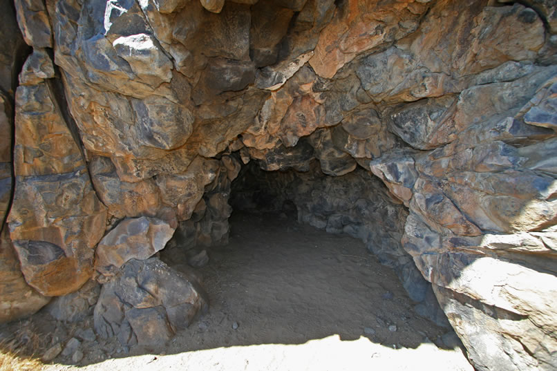 At the end of this twenty foot deep cave is a boulder blackened from innumerable cooking fires that likely extend back to the earliest inhabitants of the Stahl Site.  On this blackened boulder are faint petroglyphs that have been pecked and scratched into the dark, smoke blackened patina of the boulder.  The result is that the lighter color of the boulder itself emerges and the images appear white, almost as if painted.  