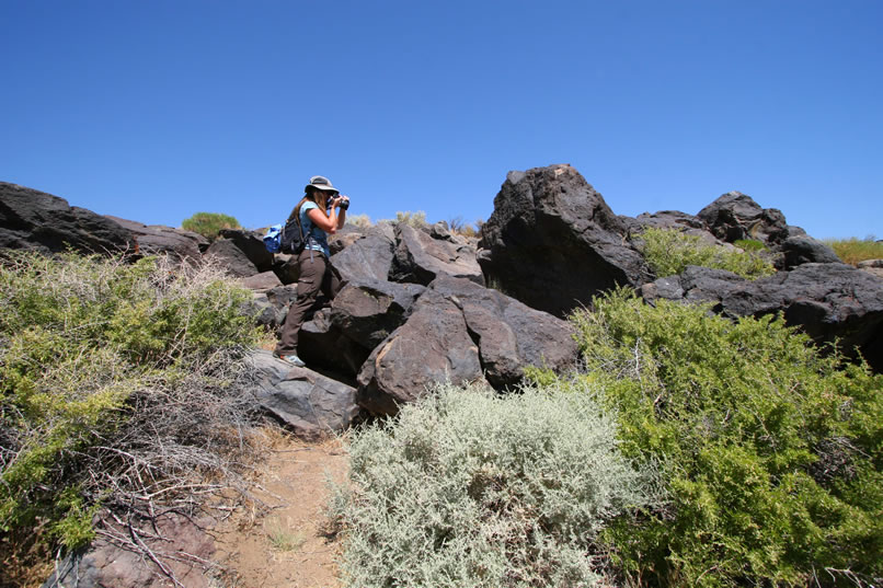 Niki photographs one of the numerous petroglyph panels that adorn the basalt lava flows that we're hiking through.