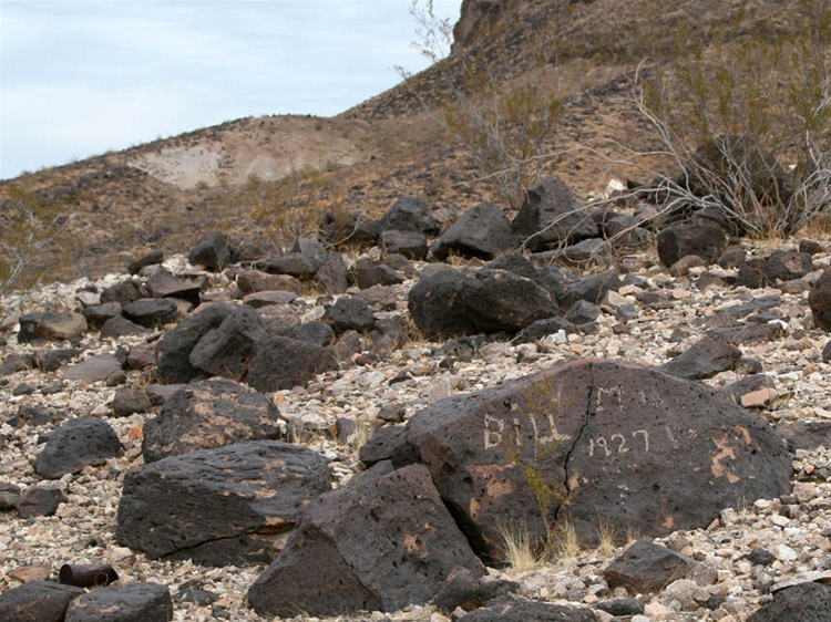 Above the shaft we spot a historic inscription pecked into a rock.