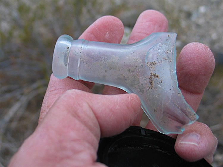 Several pieces of old bottles lie scattered around the area.