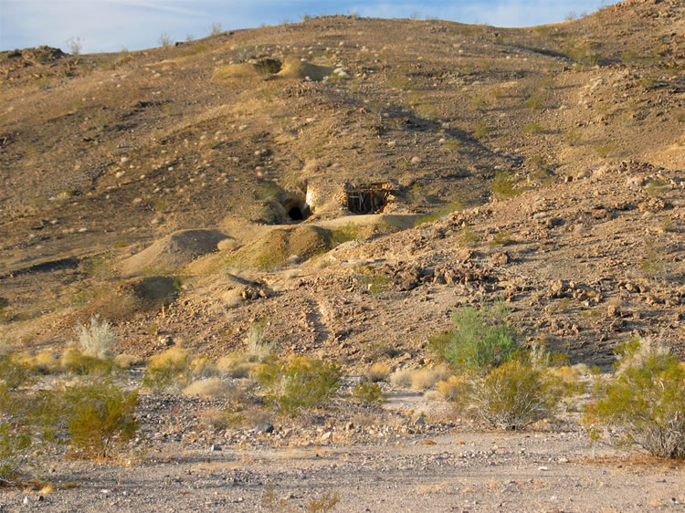 This telephoto view shows an adit to the left and some type of structure to the right.  Up above is what looks like a shaft.