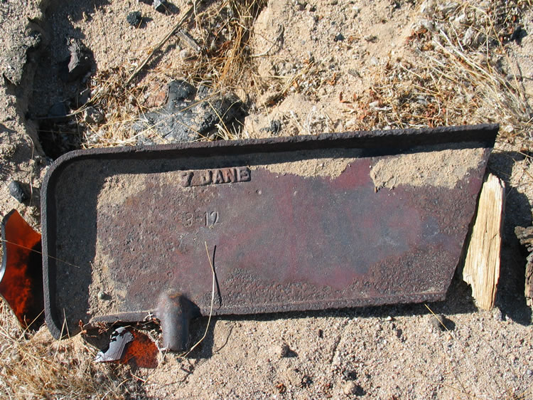 A heavy metal piece that might have been part of a stove or furnace.