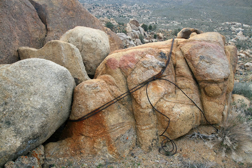 The upper cable, just like the lower end, has been fixed in place by lashing it around an available boulder.
