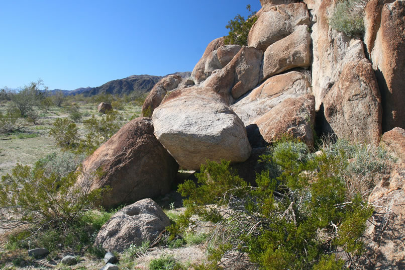 On our hike up to the mine site, we stop at a rocky hill to check it out.  To our surprise we find a small rock shelter with a bedrock mortar nearby.