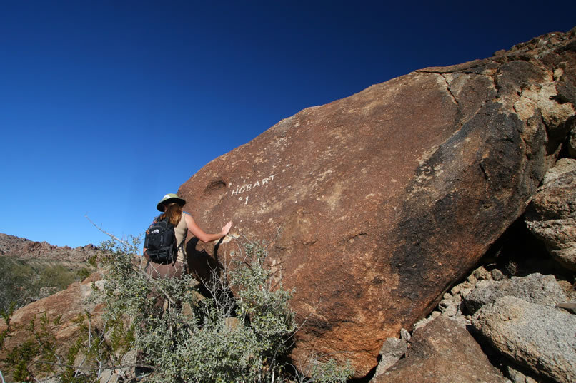 Niki checks out the boulder to see if there's anything else inscribed on it.