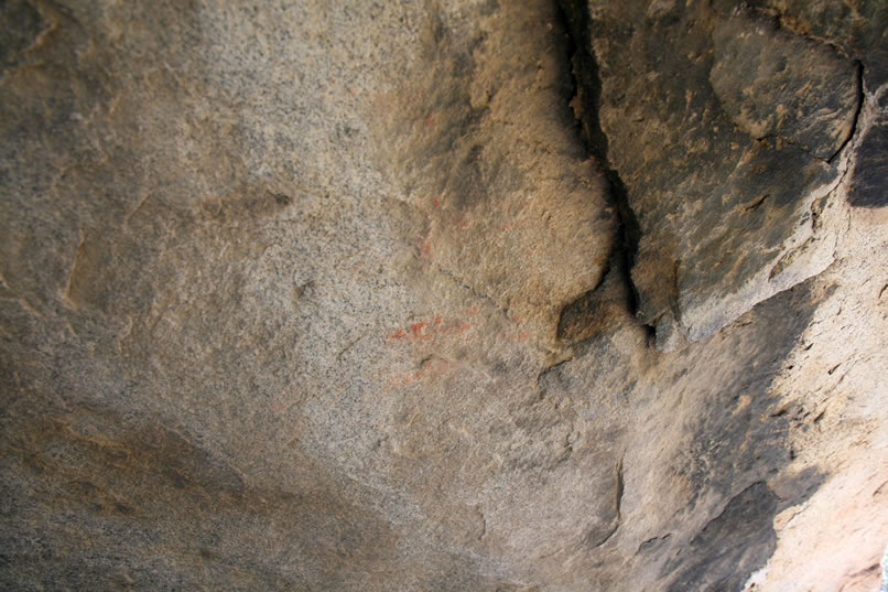 This photo of the right side of the shelter shows what appears to be a slanted black line flanked by weathered red pictos.  (Roll mouse over photo for enhanced view.)