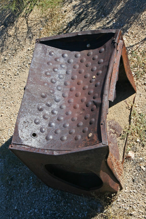 This square metal device looks as if it might have been an oven that would have been placed on top of a gasoline stove.  Such large ovens could be used to bake bread or cook roasts.