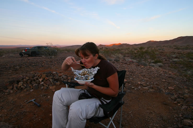 Niki digs into a great Kitchen Sink Stir Fry that's been heating on the coals of the campfire.