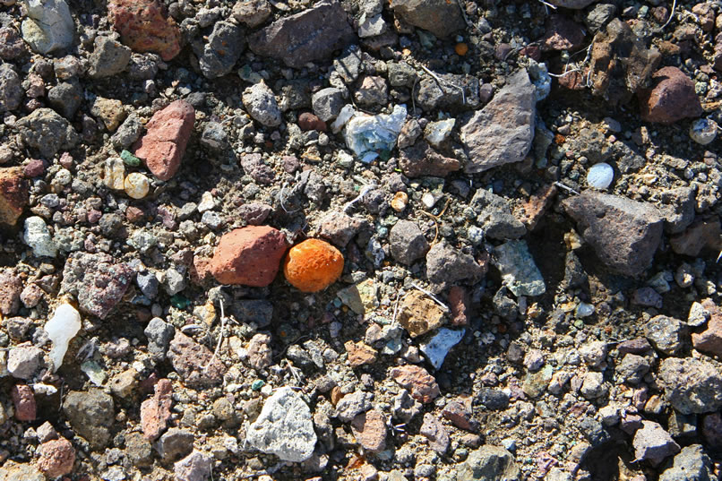 The eroded slopes of the hills were once known as a good collecting location for small nodules and geodes, as well as agate in a wide variety of colors.  In the center of this photo, you can see a small chalcedony nodule covered in an orange crust.