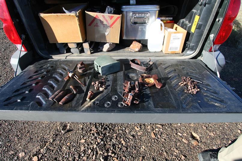 After returning to the trucks, Mohave shows us evidence that there was indeed a 1964 Desert Strike military camp nearby.  Some of the items he's found include exploded mortar bomb fins and .30 and .50 caliber machine gun belt links.  He also tells us that there were some large artillery rounds and aerial flare parts in the area.