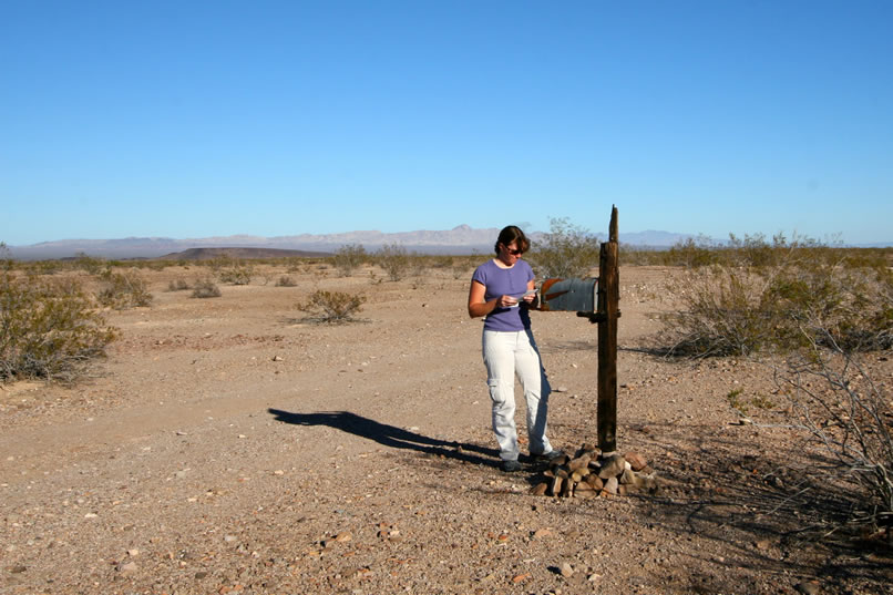 The remains of the old mail box for the burned out cabin are found at the junction of Mine Shack Road and Essex Road.  Niki looks over the many notes that have been left by visitors to this area.