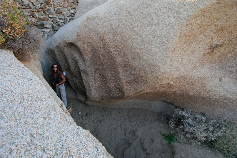 It was in the late 1800's and early 1900's when ranchers built the rock and concrete dams which have come to be known as the Twin Tanks.  However, long before that, the numerous natural tanks here had been used by the Indians.  In fact, those white pock marks to the right of Niki are an early form of petroglyph known as cupules.  The more modern stone dam above Niki makes for some nice constrast to the ancient cupules below!