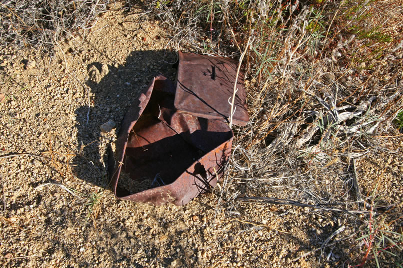 Scattered throughout the surrounding area are bits of metal and old cans, mostly of the hole and cap variety.