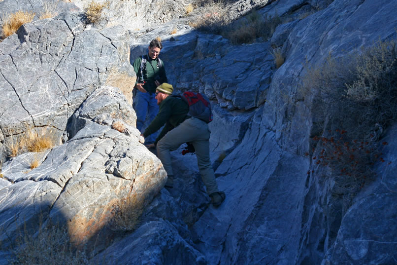 Guy and Dan clamber up from the desert floor and into the narrow chute of  the lower canyon first and then lend a hand to the rest of us.