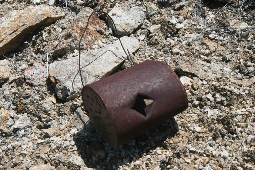 Here's a home made lantern often referred to as a Shadowgee.  Wire formed the handle while a candle was stuck into the hole punched in the side of the can.  Smaller holes let in air while most of the light shone out of the open end of the can.