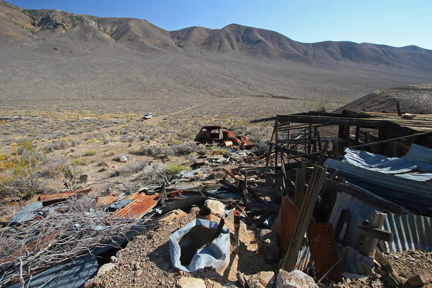 A look at the side of that two story structure and the old car nearby.