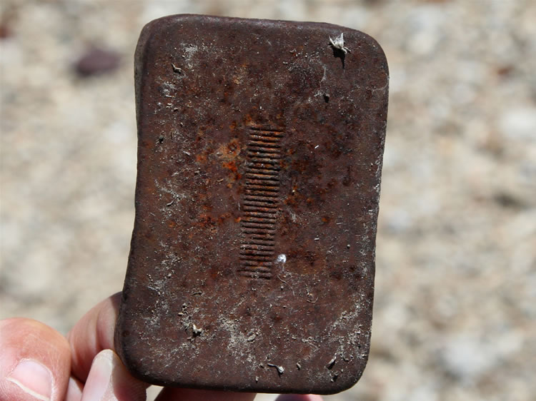 Possibly a cigarette tin with a ridged area on the bottom for striking matches.