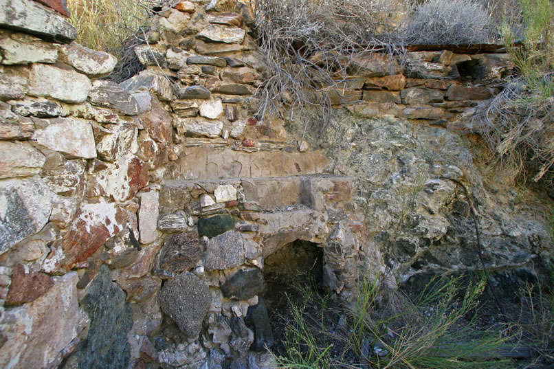 In the corner formed by the down canyon wall and the back wall, which is composed of rocks stacked up against the side of the canyon itself, is a sturdy fireplace.