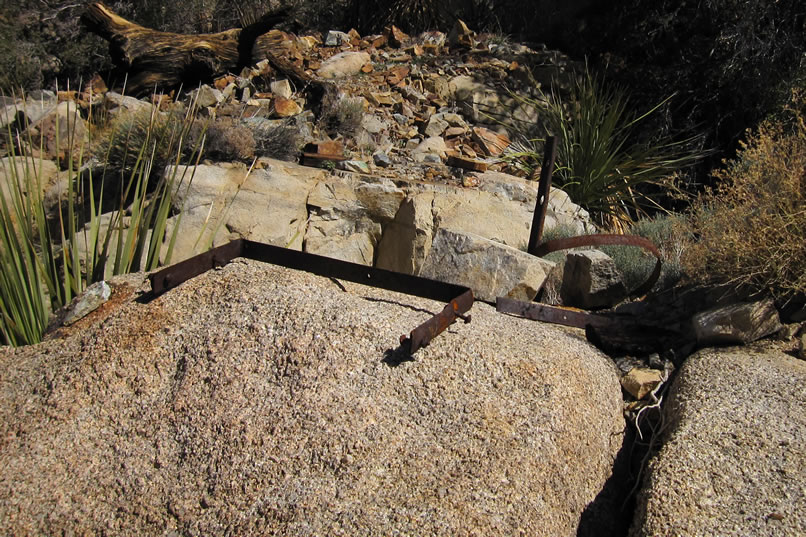Some heavily rusted metal objects are found on a nearby boulder.