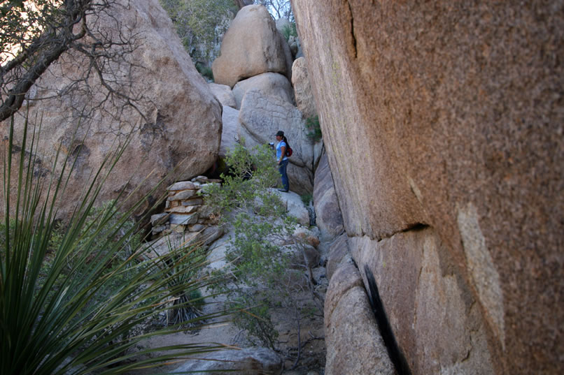 Here you can see Cindy looking into the naturally hollowed out boulder.  Notice the low stacked rock wall just in front of the boulder.