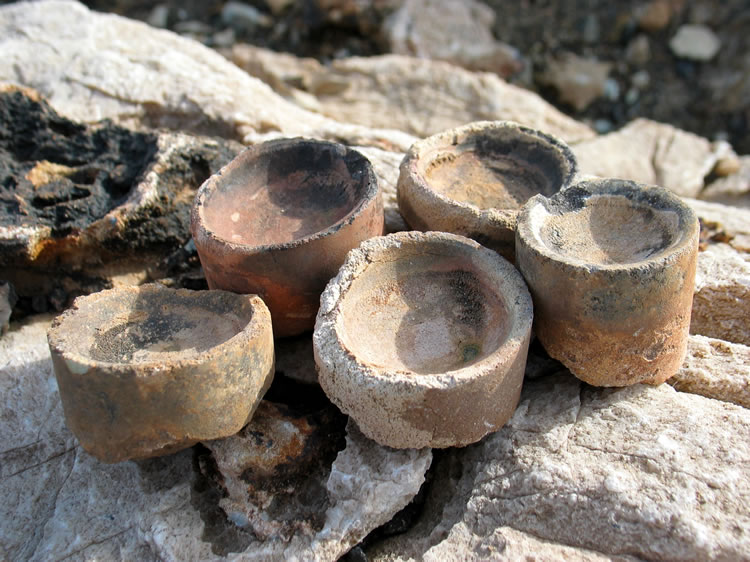 After removing the slag, the buttons of precious metal and lead are placed in these cupels.  The cupels are made of bone ash and absorb the lead created by the fluxes.