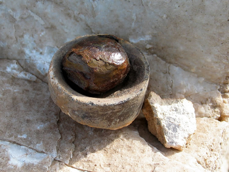 A glassy ball of slag in one of the cupels.