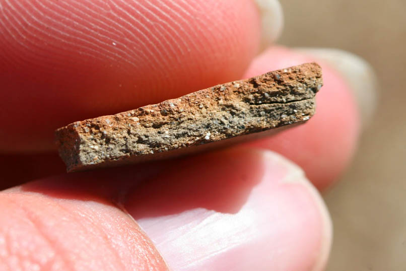 A closer look at the edge of the pottery fragment.