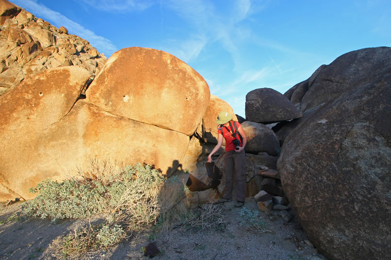 The days are short in January and we're running out of daylight.  As we hustle around, we find a little niche in the boulders that has quite a bit of debris including wire cables.  We also note several holes in the boulders.  These can be seen to the left of Niki and about a foot above her head.  Was this area used as a terminus for the tramway coming down from the upper level of the mine?
