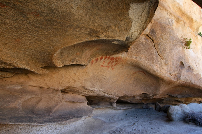 Nestled in the shadow of a rocky overhang are several panels of striking red pictographs done in a style known as rectilinear abstract.  These are very similar to other examples of Cahuilla or Luiseno rock art found further to the south.