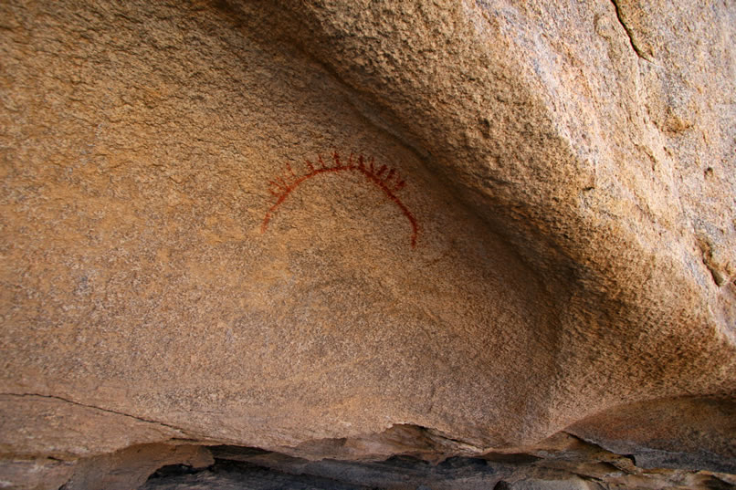 Finally, we come to the sunburst motif.  During a 1984 summer solstice observation, an "intense, vertical, finger-like beam of sunlight" pierced the shadows of the shelter and pointed directly to the sunburst motif.  Consequently, it's thought that this site may have been used by shamans to predict this important seasonal cycle which is tied to the food supply of the culture.   It would have been the shaman's duty to watch, interpret and if necessary to intervene with the appropriate supernatural magic to maintain the seasonal balance which was so important.