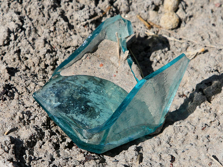 A delicate blue colored fragment from a square glass container.