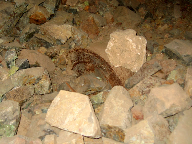 A large piece of equipment can just be seen under this rock fall.