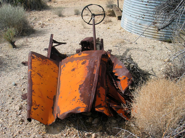 Next to the old tank are the partial remains of a racy looking early auto.