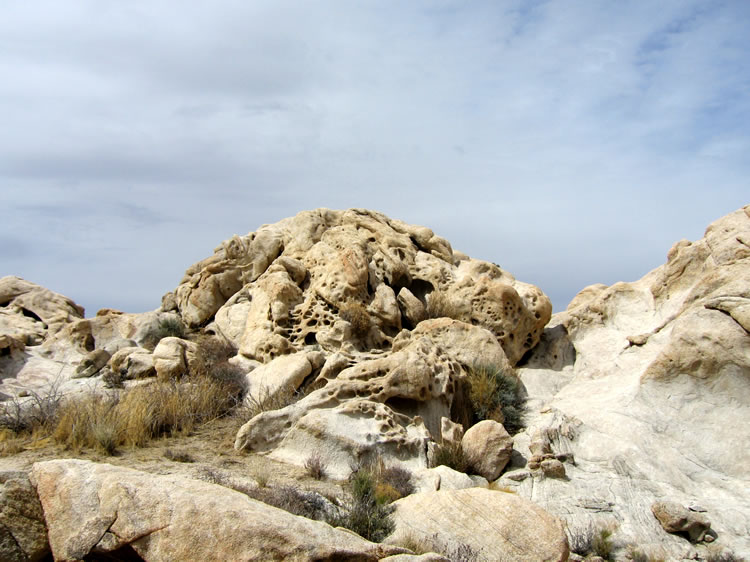 The surrounding rocks are deeply pitted and eroded.