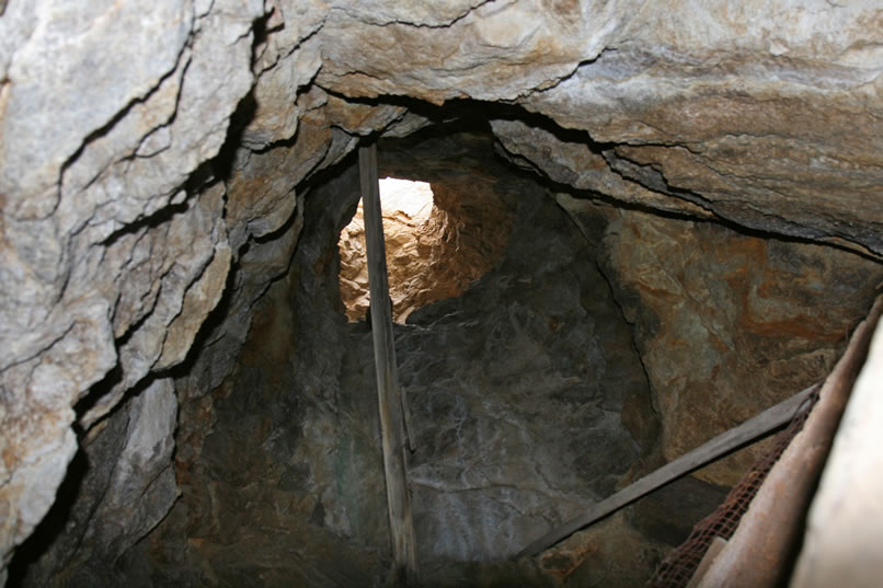 As she crosses she takes this photo looking up the shaft that drops down from above.  We'll check that shaft out from above when we're done in this tunnel.