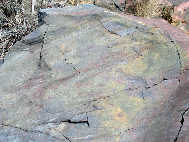 The hike back goes swiftly as we recount the day's finds.  Along the way we find this water worn boulder in the wash that shimmers in colors that resemble an oil slick.